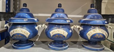 Set of three 19th century English pottery blue ground two-handled apothecary jars and domed
