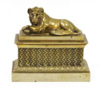Early 19th century brass inkstand, cover and liners, surmounted by a recumbent lion cover, the