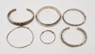Collection of six silver bangles including a plain hinged bangle, engraved adjustable bangle,