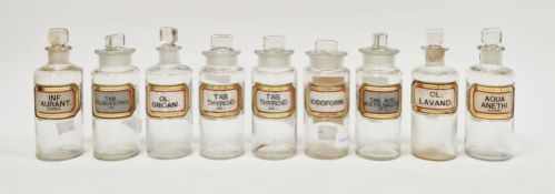 Nine early 20th century 'label under glass' apothecary bottles and stoppers, each of cylindrical