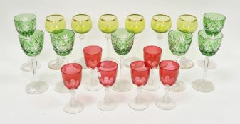 Collection of coloured and cut glass glasses comprising six cranberry tinted wine glasses, on cut