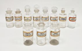 Ten early 20th century 'label under glass' apothecary bottles and assorted stoppers and stopper-