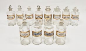 Twelve early 20th century 'label under glass' apothecary bottles and stoppers, each of cylindrical