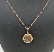 9ct yellow gold circular pendant locket with engraved scroll decoration to front, 3.1cm long held on