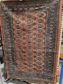 Bokhara-type red ground wool rug, 20th century, the centre with a repeating Tekke gul motif,