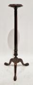 Victorian mahogany torchere in the George III manner, the circular top with carved edge, on a fluted