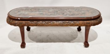 Chinese hardwood coffee table with rounded ends, the top with a relief carved battle scene and glass