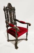 Large Victorian heavily carved oak elbow chair in the Jacobean manner, with red upholstered arm pads