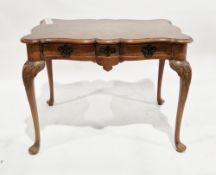 Early 20th century walnut side table/desk in the Queen Anne manner, the shaped top with thumbmoulded