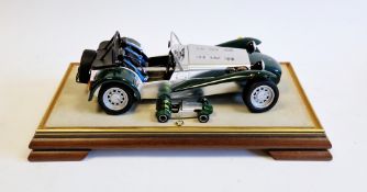 Diecast Caterham Super 7 car in a glazed display case, in green and another by Kyosho 1/43