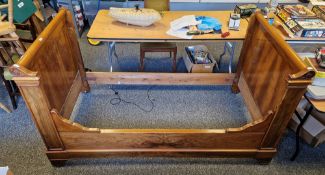 French-style walnut single sleigh bed frame, with cylindrical top rails and having carved foliate