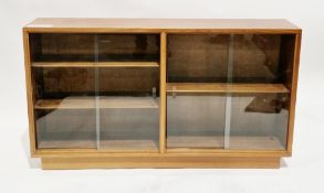 Mid-century teak low library bookcase, comprising two sections, both with a pair of glass sliding