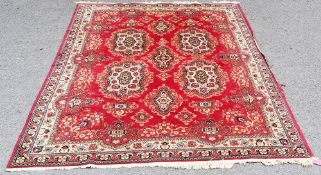 Large Kirman-Super Persian style red ground rug, decorated with stylised medallions within a border,