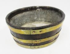 George III coopered oak and brass bound wine cooler of oval form with lead liner, 20cm high x 42cm
