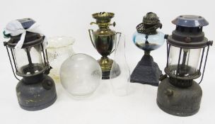 Two Victorian oil lamp bases, one with blue glass well and embossed iron base, the other brass of
