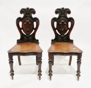 Pair of 19th century mahogany hall chairs, the shaped backs carved with foliate scrolls, central
