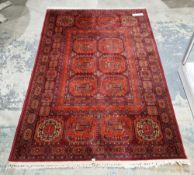 Belgium ' Basra ' red ground wool rug, decorated with two rows of stylised medallions within a