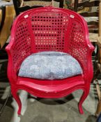 French bergere tub chair painted a bright fuschia pink, with floral carved cresting, shaped seat, on