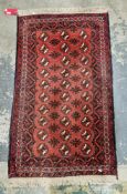 Turkmen type red ground wool rug, decorated with three rows of guls within a border, 149cm x 88cm