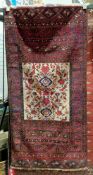 Persian style Belouch red and cream ground wool rug, decorated with a cream rectangular central