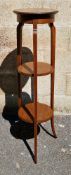 Edwardian mahogany and satinwood inlaid jardiniere stand, the circular top over two shelves, on