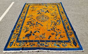 Chinese wool mustard and blue wool rug, decorated with a central medallion and flowers and