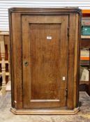 George III oak hanging corner cabinet having a carved reeded border to sides and base, the single