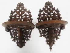 Pair of Black Forest wooden folding bracket shelves of demi-lune form, the back panels with