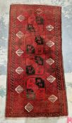 Turkmen type red ground wool runner rug, decorated with a four of four medallions within a geometric