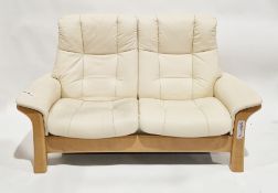 Ekornes Stressless cream leather two-seater reclining sofa with individual reclining action, on a
