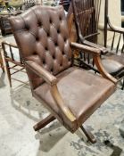 Canadian Brown leather-effect upholstered and studded office swivel elbow chair, with button back,