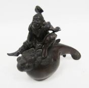Japanese late Meiji period (1868-1912) okimono depicting a figure of a man riding a stylised fish,