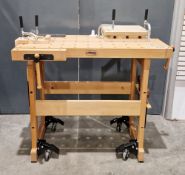 Woodworkers beech workbench on retractable wheels with two wood vices, various saws and clamps and a