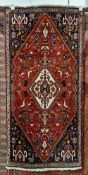 Persian style Qashqai red ground wool rug, decorated with a central medallion surround by birds