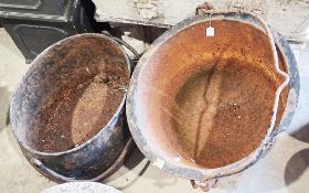 Two antique cast iron hanging cooking pots or cauldrons, the first oval in shape, 60cm long x 29cm