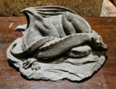 Contemporary resin model of a dragon, recumbent, sleeping on a rocky base, 25cm wide