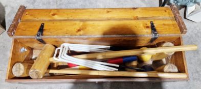 Croquet set contained within a wood and metal bound box.
