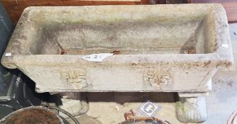 Reconstituted stone trough planter with moulded lion's masks supported on two feet in the form of