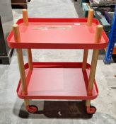 Red metal and beechwood two-tier trolley, the two tiers with raised sides, on castors, 50cm wide x