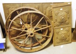 Pair of cast iron antique cart wheels, 62cm diameter and a part floral moulded cast iron fire