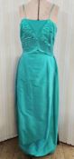 Raw silk emerald green evening gown with spaghetti straps, a pleated bodice and bow detail to the