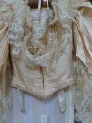 A Victorian wedding dress, cream coloured satin with lace collar and detail, beaded decoration to