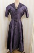 A blue satin cocktail dress labelled Hershelle with ruched detail to the 'V' neck bodice, button
