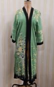 A 1920's Chinese style dressing gown, green printed with yellow apple blossom and with black trim to