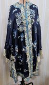 A Chinese satin robe embroidered with blue flowers and butterflies, embroidered panels and brass