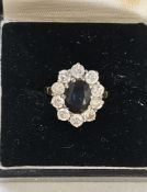 18ct gold, sapphire and diamond cluster ring, the oval sapphire surrounded by ten diamonds, each