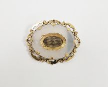 Victorian yellow metal and chalcedony mourning brooch, oval with central woven hair inset, scroll