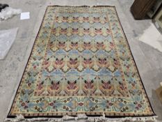 Liberty & Co 'Ianthe' hand knotted blue ground wool rug with floral border, purchased by the