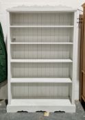Large pale blue painted pine bookcase, the shaped top over four fixed shelves with panel back, on