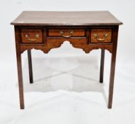 George III oak lowboy of rectangular form with three drawers to the front, shaped apron, brass